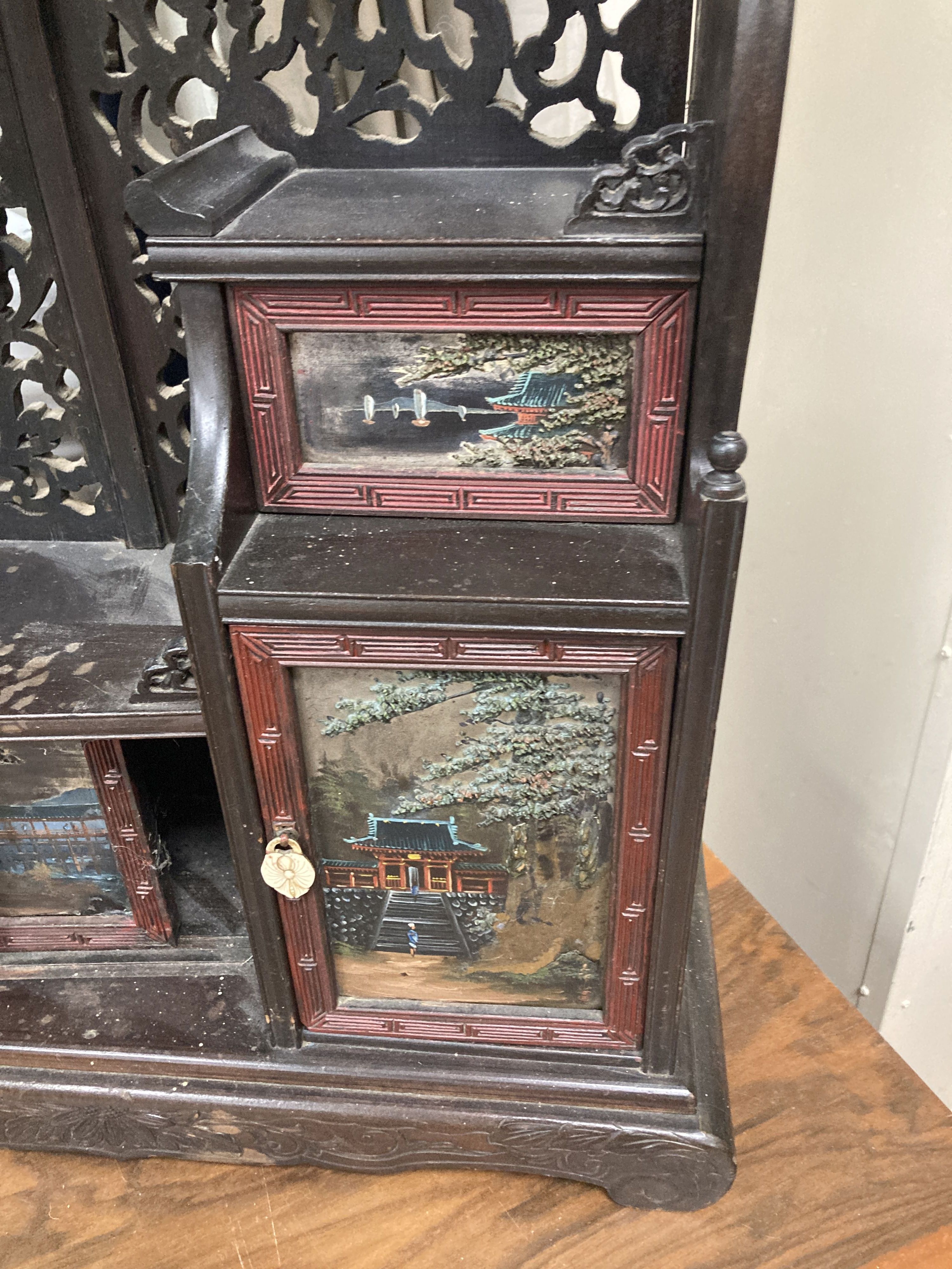 A 20th century Chinese carved cabinet with painted hinged cupboard doors, 79cm height, width 52cm, depth 18cm